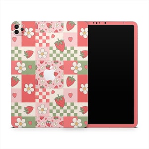 May include: A pink iPad case with a patchwork design featuring strawberries, flowers, hearts, and checkered squares. The case has a matching pink frame and a black screen.