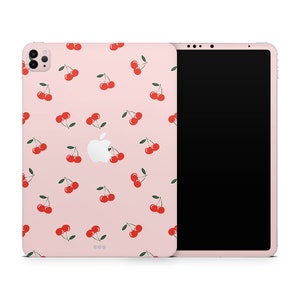 May include: A pink iPad case with a white apple logo and a repeating pattern of red cherries on a pink background.