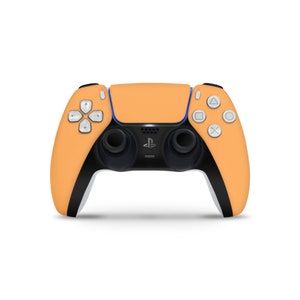 May include: A bright orange PlayStation 5 DualSense wireless controller with white buttons and black accents.