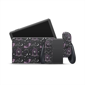 Op de afbeelding: Een zwarte Nintendo Switch-console en controllers met een aangepaste skin met een herhalend patroon van vleermuizen, manen, sterren en gotische boogvensters in paars en wit. De console staat op een witte achtergrond.