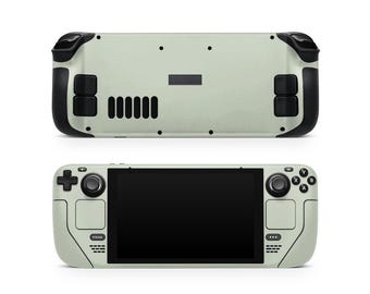 Peut inclure: Console de jeu portable vert clair, vue de face et de dos. La vue de face affiche un écran noir, des boutons de commande et le mot "STEAM". La vue arrière montre des évents et des poignées noires.