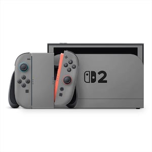 May include: A gray Nintendo Switch console with two detachable controllers. The left controller has blue accents, while the right controller is coral. The console has the text "Switch 2" printed on the front.