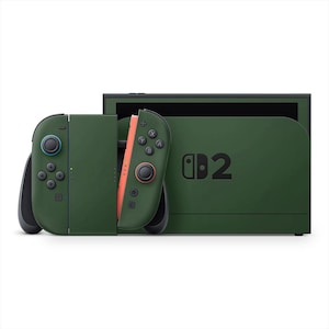 Puede incluir: Una consola Nintendo Switch verde con dos mandos Joy-Con desmontados. El mando izquierdo tiene botones azules y el mando derecho tiene botones naranjas. La consola tiene el número "2" impreso.