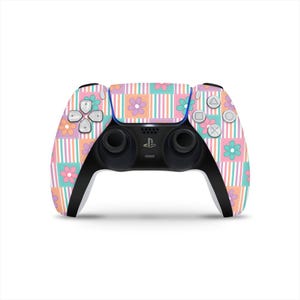 Peut inclure: Une manette PlayStation 5 avec un motif floral et rayé coloré. Le design présente des couleurs pastel, notamment rose, orange, bleu et vert. La manette a des poignées et des boutons noirs.