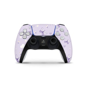 Puede incluir: Un mando de PlayStation 5 morado y blanco con un diseño de mariposa y flores.