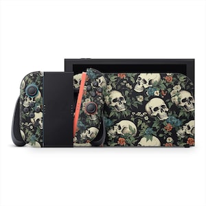 Puede incluir: Una consola Nintendo Switch negra con un diseño floral de calaveras en los Joy-Cons y la parte trasera de la consola. El diseño presenta calaveras blancas, hojas verdes y flores rojas y azules sobre un fondo negro.