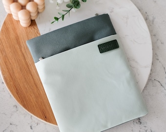 May include: A green and light green zippered pouch with a small leather tag that says "Stickie Fox".