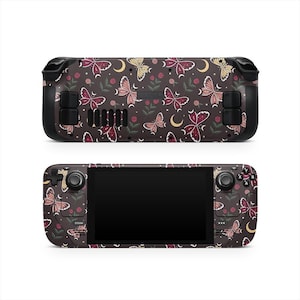 May include: A handheld gaming console with a dark brown background and a repeating pattern of butterflies, moons, and flowers in shades of pink, yellow, and white. The console has black buttons and a black screen.