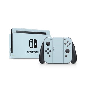 May include: A light blue Nintendo Switch console with black accents. The console features a screen, a dock, and detachable controllers. The word "SWITCH" is printed in black on the console.