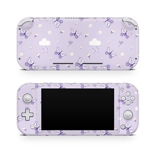 May include: A purple Nintendo Switch Lite console with a butterfly and flower pattern. The console has a white screen and white buttons.