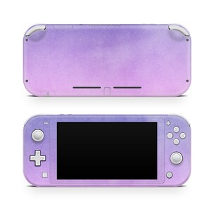 May include: A purple and pink ombre Nintendo Switch Lite console with a textured finish. The console is shown in both the closed and open positions.