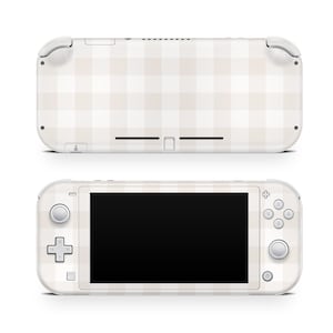 Peut inclure: Une console Nintendo Switch Lite blanche avec un motif à carreaux beige et blanc à l'arrière et à l'avant. La console est présentée à la fois en position fermée et ouverte.