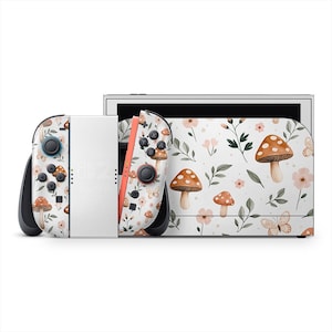 May include: A white Nintendo Switch console and controllers with a whimsical mushroom and floral pattern. The design features brown mushrooms, pink flowers, green leaves, and butterflies. The controllers have black buttons and joysticks.