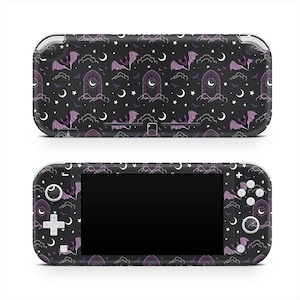 May include: A black handheld gaming console with a repeating pattern of purple bats, crescent moons, stars, and gothic archways. The console has a black screen and white buttons.