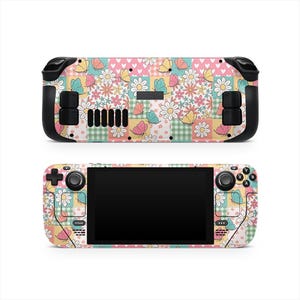 May include: Two Steam Deck consoles, one above the other, featuring a colorful floral and butterfly design. The design includes daisies, butterflies, and patchwork patterns in pastel colors. The consoles have black control buttons and a black screen.