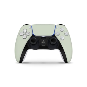 May include: A light green and black wireless game controller with a white background. The controller has a central touchpad, two analog sticks, and various buttons, including a PlayStation logo. The design is sleek and modern.