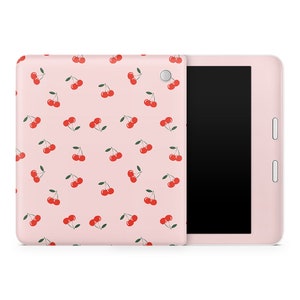 May include: A pink e-reader with a cherry pattern on the front cover. The e-reader has a black screen and a white border.