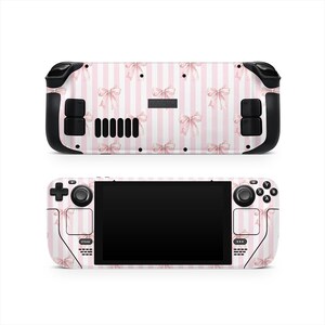 May include: A pink and white striped Steam Deck skin featuring a pattern of pink bows. The skin covers the front and back of the handheld gaming device, with black control buttons and a black screen.