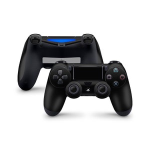 May include: Two black PlayStation 4 controllers, one lying flat and the other standing upright. The controller has a black and gray design with buttons for up, down, left, right, triangle, square, circle, and X.