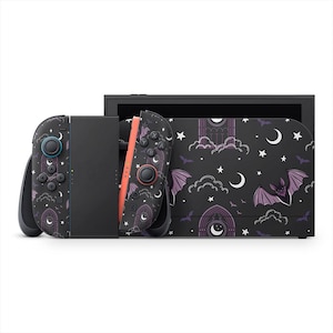 May include: A black Nintendo Switch console and Joy-Cons with a gothic bat and moon design. The design features purple bats, white stars, and crescent moons on a black background. The Joy-Cons have blue and red buttons.
