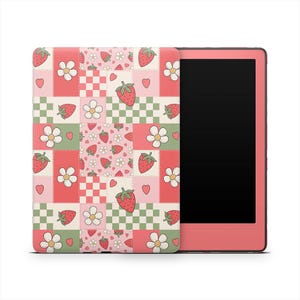 Könnte beinhalten: Ein rosa E-Reader mit einer gemusterten Hülle mit Erdbeeren, Blumen, Herzen und karierten Quadraten in Rosa, Grün und Weiß. Der Bildschirm des E-Readers ist schwarz.