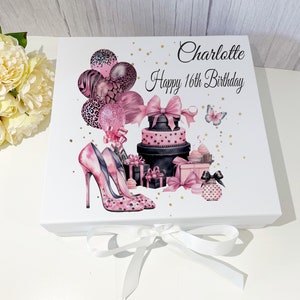 May include: White gift box decorated with pink high heels, balloons, a tiered cake, and gifts. The text "Charlotte Happy 16th Birthday" is printed on the box. A white ribbon is tied around the box.