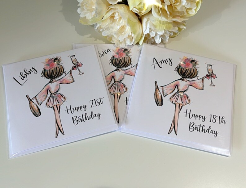 K&ouml;nnte beinhalten: Drei personalisierte Geburtstagskarten mit einer Cartoon-Illustration einer Frau im Bademantel, die ein Glas Champagner h&auml;lt. Die Karten sind wei&szlig; mit schwarzem Text und tragen die Namen Libby, Erica und Amy. Der Text enth&auml;lt auch die S&auml;tze "Happy 21st Birthday" und "Happy 18th Birthday".