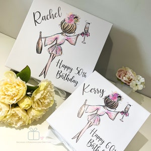 K&ouml;nnte beinhalten: Zwei wei&szlig;e Geschenkboxen mit Illustrationen von Frauen, die Champagnergl&auml;ser halten. Die Boxen sind mit floralen Akzenten und dem Text "Happy 50th Birthday Kerry" und "Happy 60th Birthday Rachel" verziert.