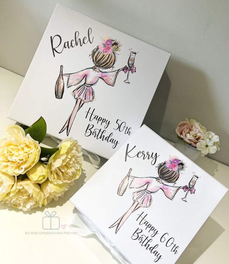 K&ouml;nnte beinhalten: Zwei wei&szlig;e Geschenkboxen mit Illustrationen von Frauen, die Champagnergl&auml;ser halten. Die Boxen sind mit floralen Akzenten und dem Text "Happy 50th Birthday Kerry" und "Happy 60th Birthday Rachel" verziert.