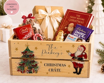 May include: A wooden Christmas crate featuring a printed illustration of a decorated tree and Santa Claus, with the text The Peaberg's CHRISTMAS CRATE. The crate contains a gift box with a cream ribbon, a book, and various chocolate treats.
