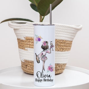 K&ouml;nnte beinhalten: Ein wei&szlig;er Edelstahlbecher mit einem rosa und violetten Blumendesign und einer Cartoon-Illustration einer Frau, die eine Flasche Champagner und ein Glas h&auml;lt. Der Becher ist mit dem Namen "Olivia" und dem Text "Happy Birthday" bedruckt.
