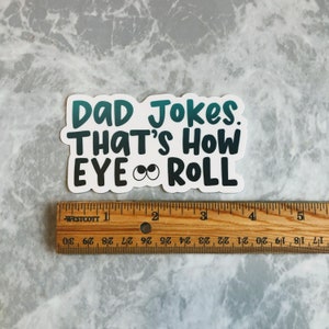 May include: A white sticker with the text "Dad Jokes. That's How Eye Roll" in teal and black lettering. The sticker is approximately 3 inches wide.