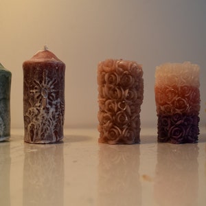 pequeñas velas con ramas de abeto y velas y decoradas con rosas en rosa, rojo, verde, naranja