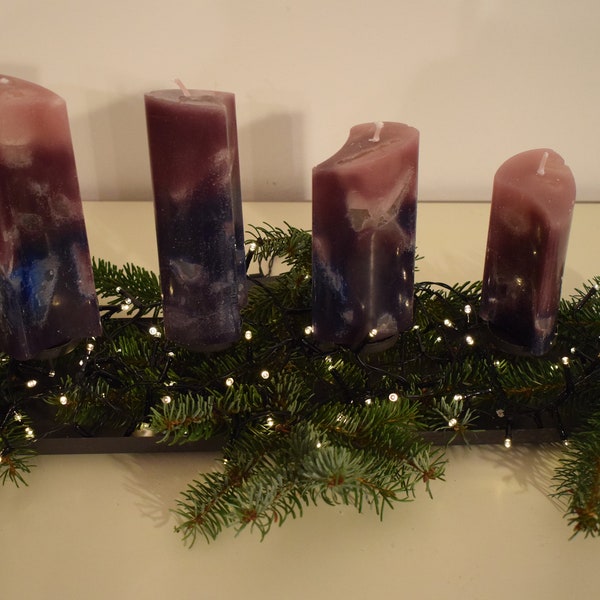 Purple pink Advent candles in a curved shape of different sizes