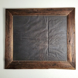K&ouml;nnte beinhalten: Ein rustikaler Holzrahmen mit einem dunkelgrauen Papierhintergrund. Der Rahmen ist aus recyceltem Holz gefertigt und hat eine nat&uuml;rliche, verwitterte Optik.