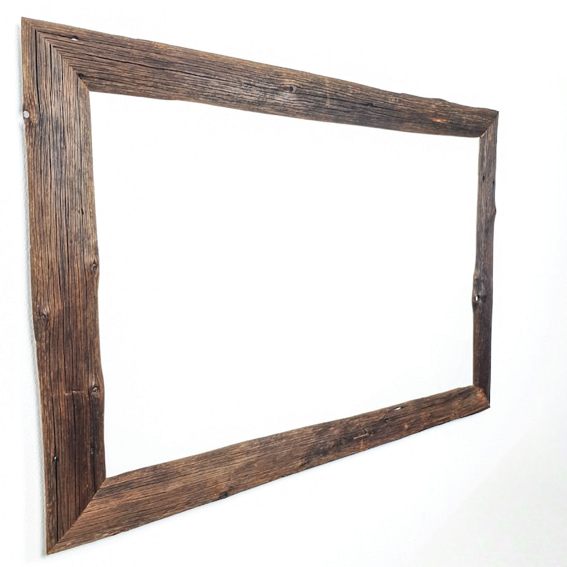 K&ouml;nnte beinhalten: Ein rustikaler Holzrahmen mit einer nat&uuml;rlichen braunen Oberfl&auml;che. Der Rahmen ist aus recyceltem Holz mit Knoten und Maserungen. Es ist ein rechteckiger Rahmen mit einem einfachen Design.