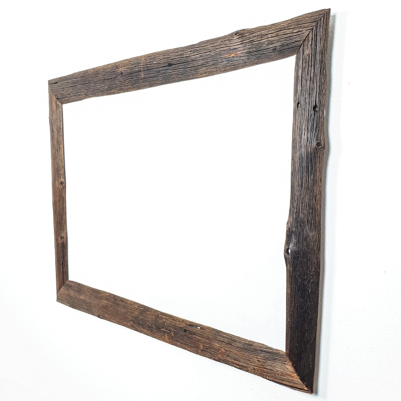 K&ouml;nnte beinhalten: Ein rustikaler Holzspiegelrahmen mit einer nat&uuml;rlichen Holzoptik. Der Rahmen ist rechteckig und aus recyceltem Holz mit Knoten und Unvollkommenheiten gefertigt.