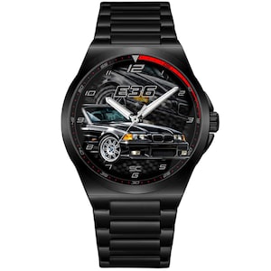 Puede incluir: Reloj de pulsera negro con correa negra y esfera negra. La esfera del reloj presenta un gráfico de coche negro con el texto "E36" y manecillas blancas. El reloj tiene un acento rojo en la parte superior.