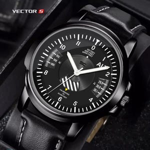 May include: Black analog watch with white hands and numerals. The watch face displays the text "VECTOR S" and "AL". The watch has a black leather band with white stitching.