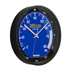 May include: A black-framed wall clock with a blue face featuring the Williams logo and Renault branding. The clock face has white markings and hands, resembling a speedometer. The clock measures approximately 10 inches in diameter.