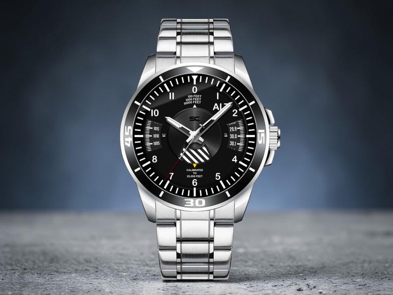 May include: A silver wristwatch with a black face and a silver band. The watch face has white markings and hands, with the numbers 0, 5, 10, 15, 30, and 45 visible. The watch has a rotating bezel and a crown on the side.