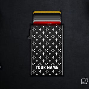 Puede incluir: Tarjetero en blanco y negro con un patrón repetido de formas florales y geométricas blancas. El texto "YOUR NAME" está impreso en blanco en la parte inferior. Varias tarjetas de crédito son visibles en el interior.