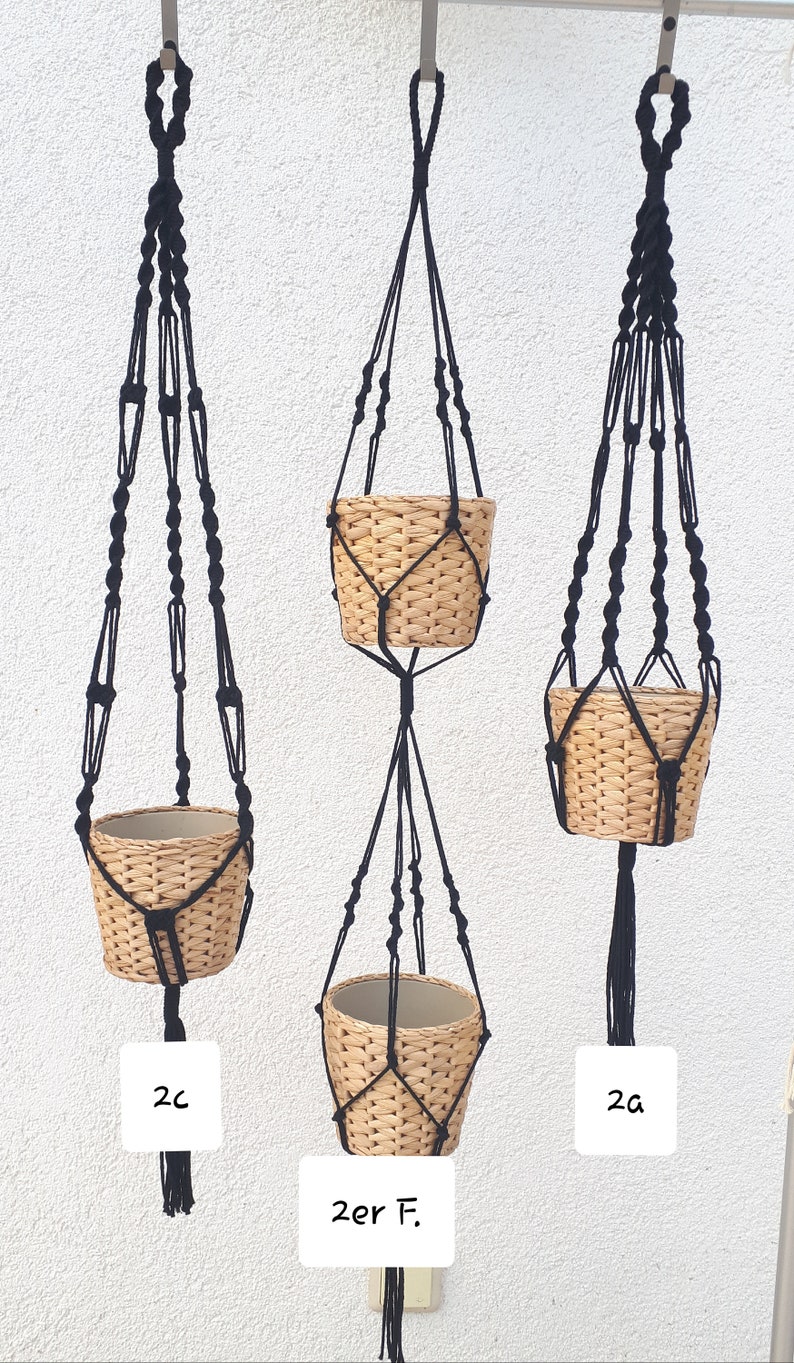 May include: Three black macrame plant hangers with woven baskets. The hangers are labeled 2c, 2er F., and 2a.