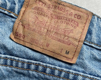 May include: A brown leather Levi's patch with the text "Levi Strauss & Co. Quality Clothing" and "550" with the words "Relaxed Fit Tapered Leg" and "M" printed on the bottom.
