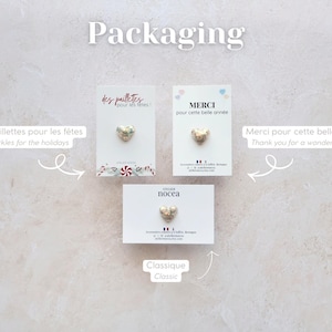 May include: Three cards with heart-shaped embellishments. The cards have text in French and English, including "Sparkles for the holidays" and "Thank you for a wonderful year." The word "Packaging" is at the top.