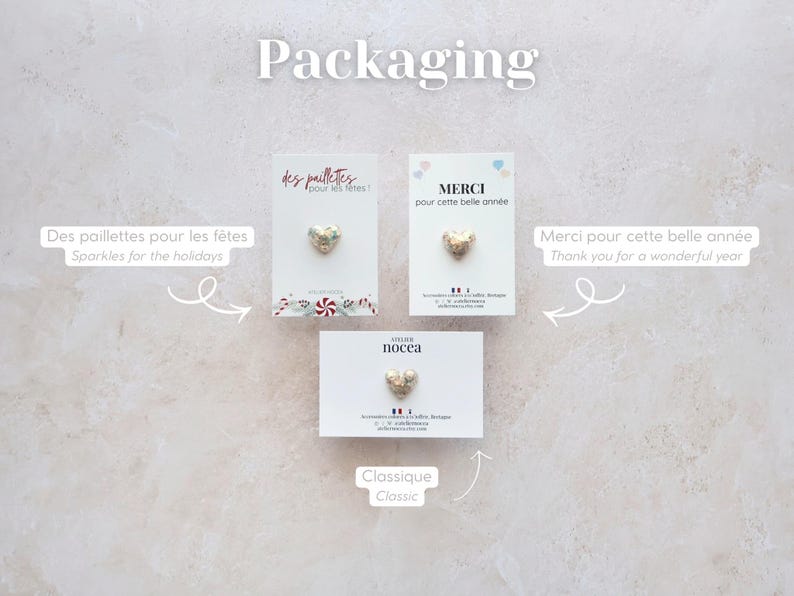 May include: Three cards with heart-shaped embellishments. The cards have text in French and English, including "Sparkles for the holidays" and "Thank you for a wonderful year." The word "Packaging" is at the top.