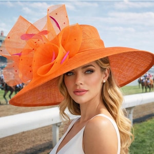 May include: A bright orange wide-brimmed hat with a large floral accent and sheer overlay. The hat features a wide brim and a decorative floral arrangement. The background shows a horse race.