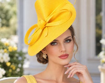 May include: A bright yellow fascinator hat featuring a structured, asymmetrical brim and a prominent, looped bow detail on the side. The hat is crafted from a woven material with a fine, textured finish, creating a bold and elegant headpiece.