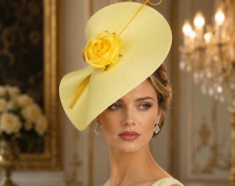 May include: A bright yellow saucer-style hat featuring a wide, circular brim with a fine, concentric ribbed texture. A large, matching yellow fabric rose is centered on the brim, accented by a thin, curved yellow stem extending upward.