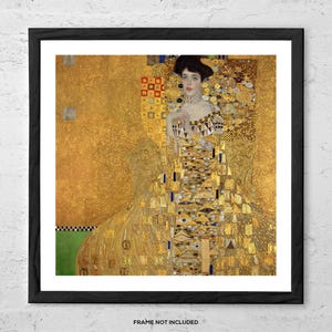 May include: Framed print of a Gustav Klimt painting. The artwork features a woman in a gold dress with intricate patterns and details. The background is a textured gold, and the frame is black. The text "FRAME NOT INCLUDED" is at the bottom.